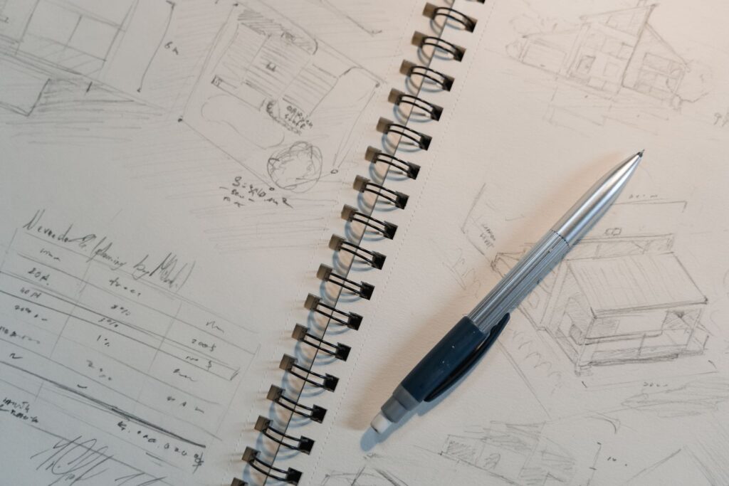 Pencil sketches of a design plan in a spiral notebook