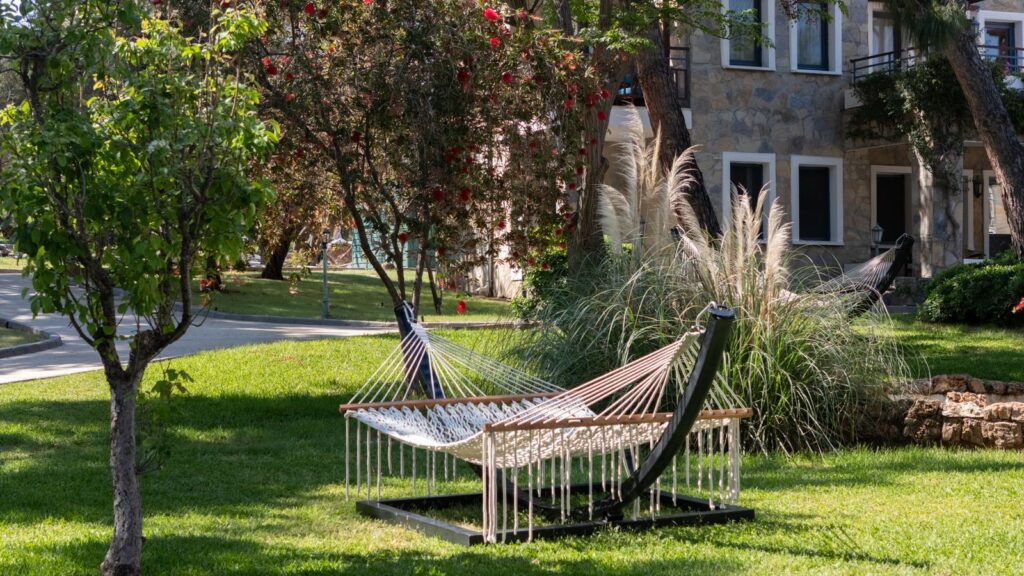 A hammock on a freestanding stand on a lawn
