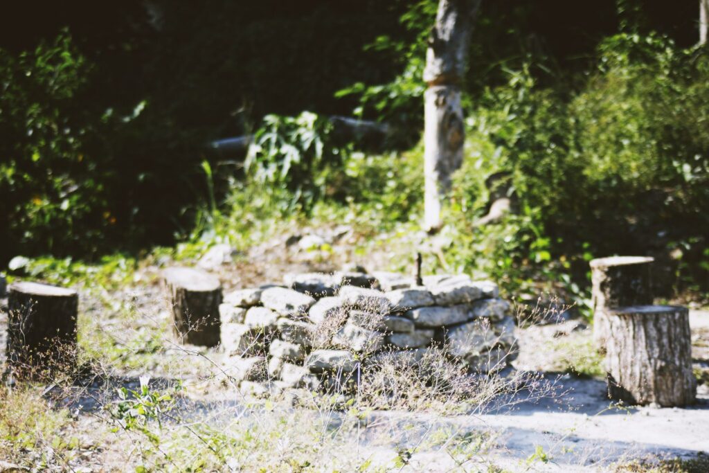 A rustic fire pit built from stacked natural stones