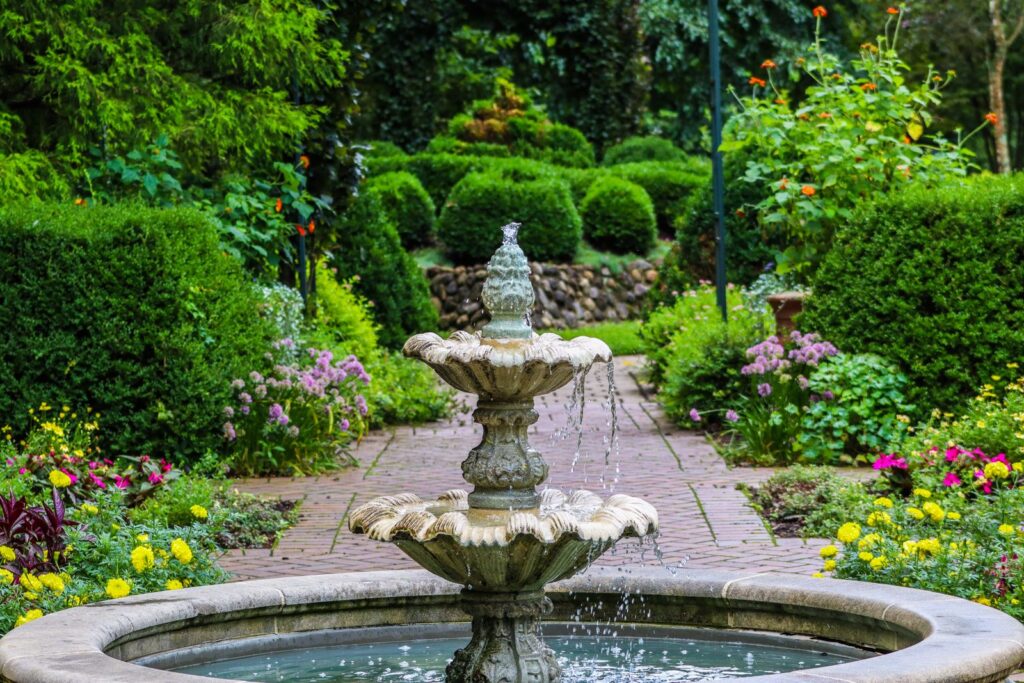 A stone fountain as the focal point at the end of a garden path