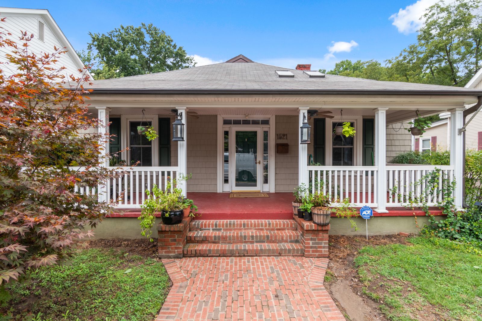 A brick paver walkway leading up to the front porch of a house