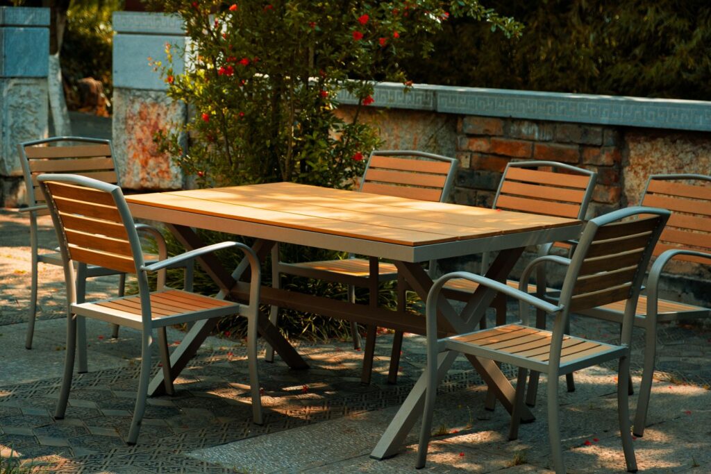 A wooden outdoor dining table and chairs on a garden patio
